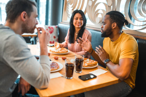 istock Multi-Cultural Group Of People In A Bar Eating Pizza 1458547531