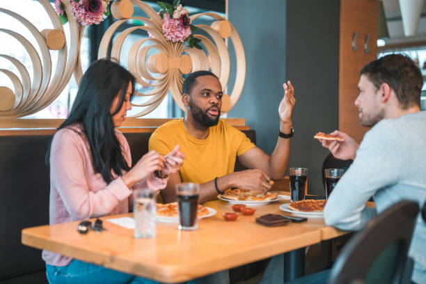 istock Multi-Cultural Group Of People In A Bar Eating Pizza 1458547704