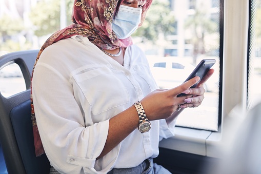 Covid, transport and smartphone of woman on social media chat, search for news information and reading bus compliance rules. Traffic, travel and muslim girl in face mask using phone for online update