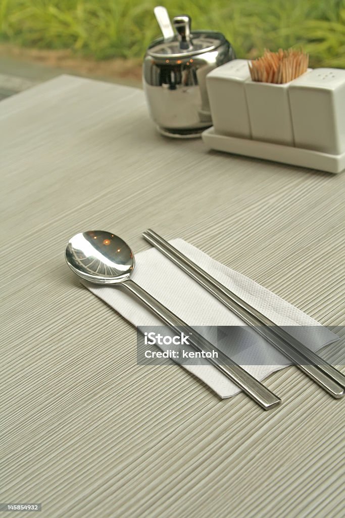 Asian Cutlery Including Spoon and Chopsticks Asian cutlery comprising of a spoon and chopsticks made of metal. Asia Stock Photo