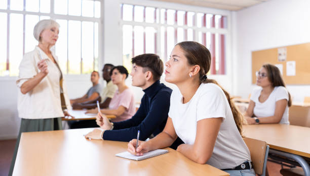 istock Young girl listening to lecture and taking notes in classroom 1458551706