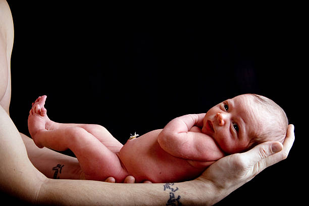 istock Newborn baby being held in her fathers hands 145855305