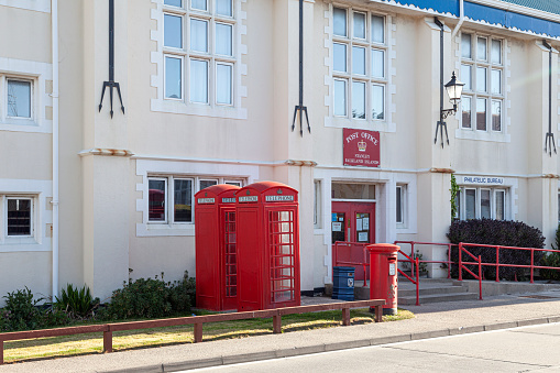 Low angle view of traditional old style UK red telephone box isolated against a building background