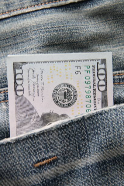 istock Dollar bills in a back pocket of jeans. 1458554464