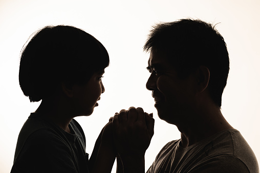 Silhouette of father and son face to face