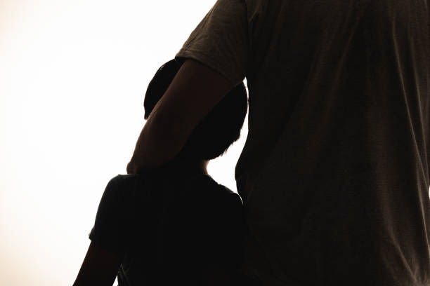 Silhouette of father and son side by side