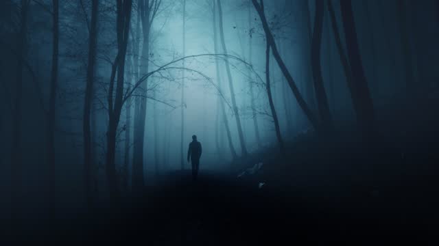 Man person walking alone in scary surreal dark blue colored blurry foggy forest landscape.