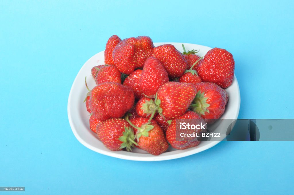 Strawberries on a plate on a blue background Antioxidant Stock Photo
