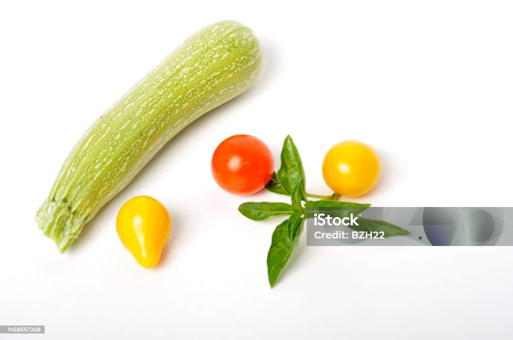 Basil, tomatoes and zucchini on a white background Basil Stock Photo