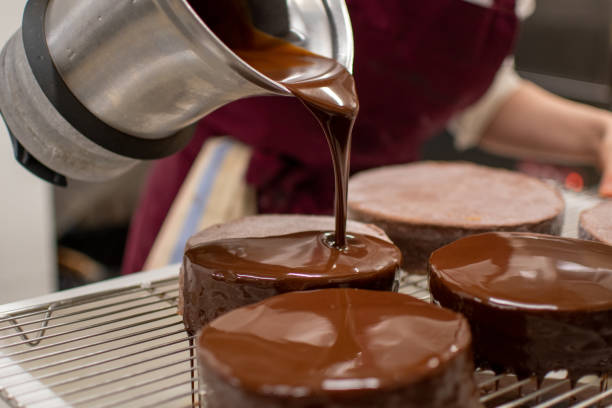 istock Pastry chef glazing chocolate cakes 1458558501