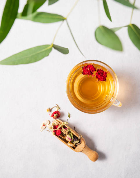 istock Fragrant herbal tea with pomegranate flowers in a glass cup on a white background with eucalyptus branches. The concept of a healthy drink for breakfast. 1458560872