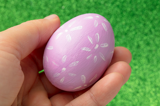 Easter egg painted in onion peel in a woman's hand on a decorative background. Natural Easter concept