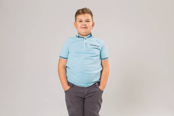 boy in studio on white background - child obesity imagens e fotografias de stock