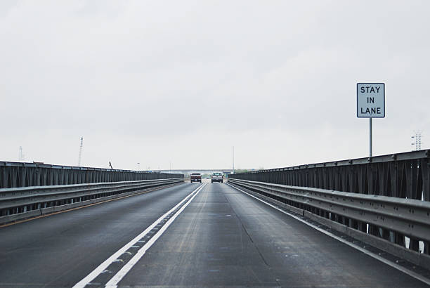 restare nella stessa corsia bridge - dividing line single line striped in a row foto e immagini stock