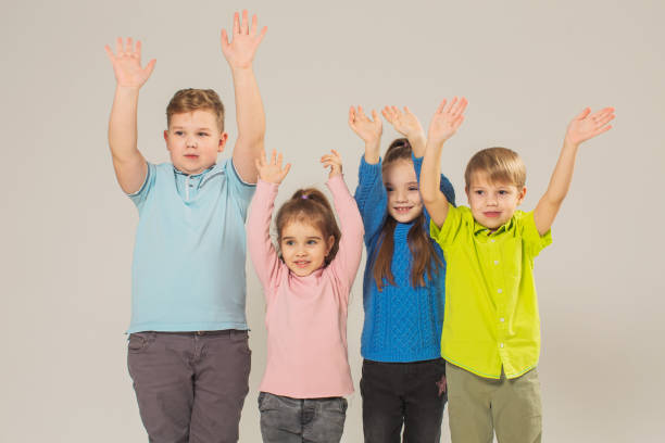 istock Two boys and two girls in studio on white background 1458564664