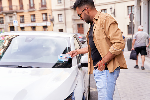 man in town renting a shared car through a mobile application by scanning a qr code