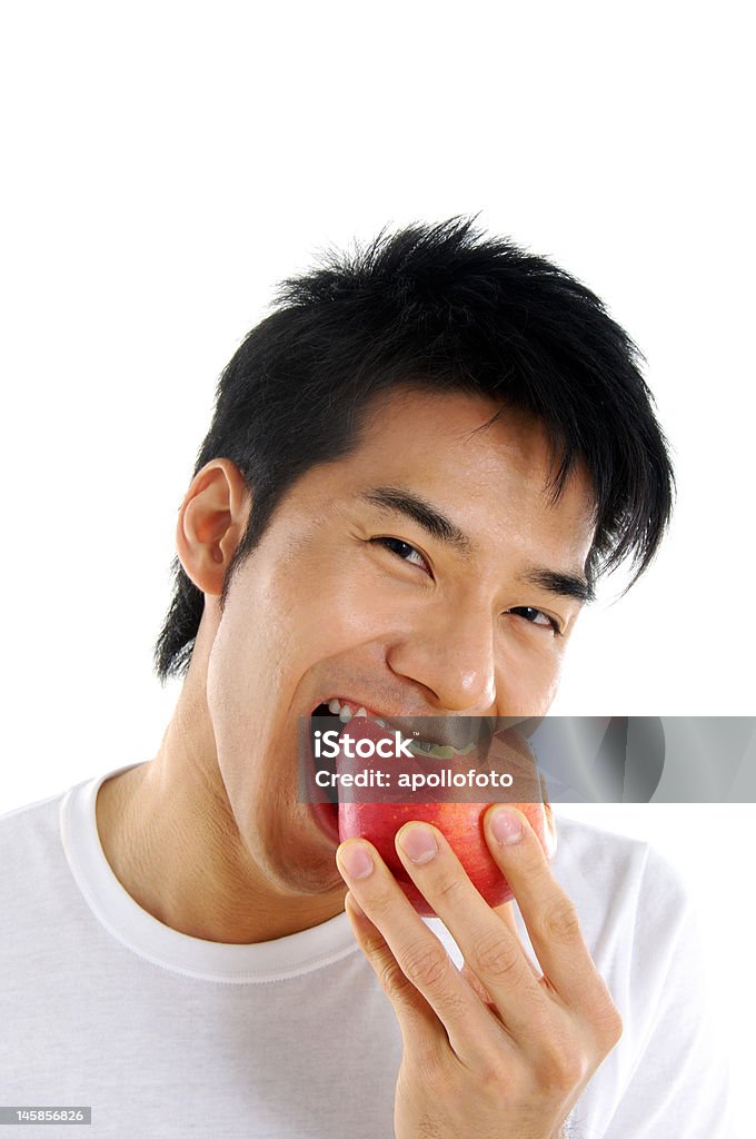 Young Asian man Young Asian man eating red apple close up Apple - Fruit Stock Photo