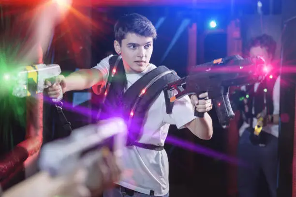 Photo of Young guy playing lasertag in arena