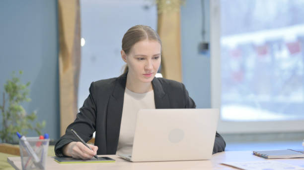 istock Female Graphic Designer Working on Laptop and Graphic Tablet 1458568611