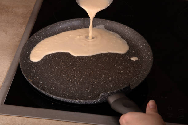 istock photo batter for thin pancakes poured on a hot pan 1458568897