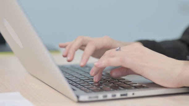 istock Close up of Hands Typing on Laptop 1458569601
