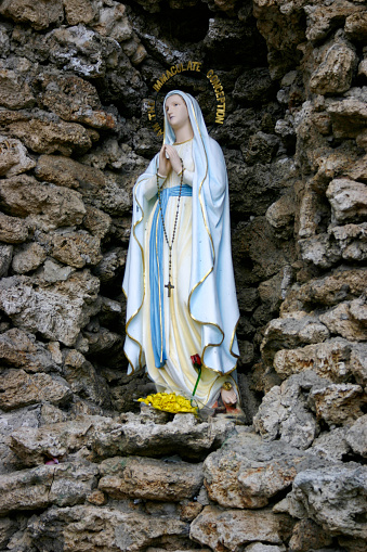 Statue of the Virgin Mary with the words “I am the Immaculate Conception” above her head