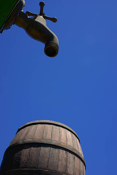 hyperbole enormous old style water tap and liquid tun stock photo