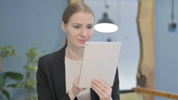 istock Businesswoman Browsing Internet on Digital Tablet 1458571848