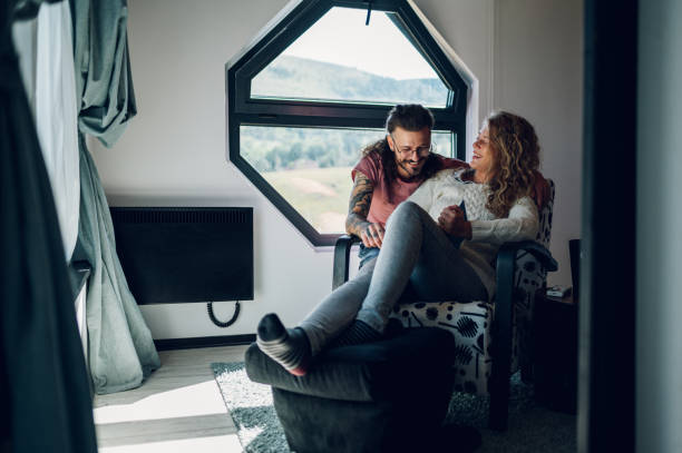 istock Man is embracing his girlfriend while she is reading a book at home 1458573916