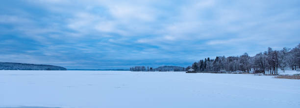 Winter landscape, lake and ice on the lake. Snow-covered trees in the park on the lake. Lake Vesijärvi in Lahti Finland. Winter landscape, lake and ice on the lake. Snow-covered trees in the park on the lake. snowfield stock pictures, royalty-free photos & images