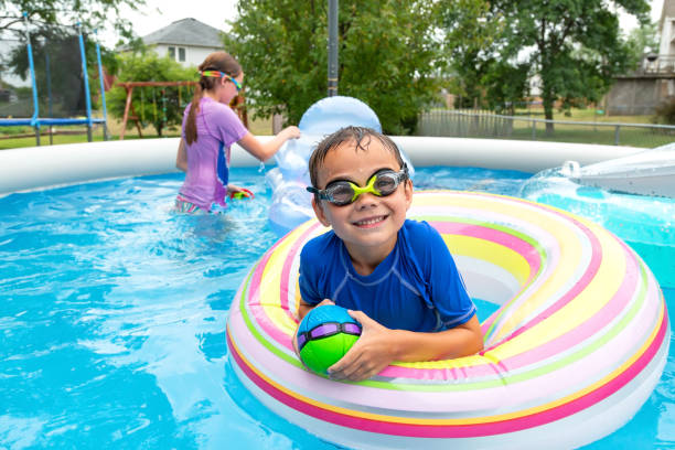 Boy In Swim Float Smiling From Pool stock photo