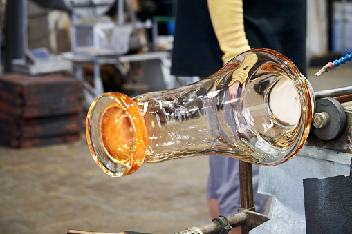 Blowing glass from raw hot mass at glassworks