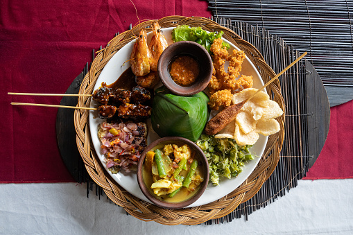 A plate of Indonesian Nasi campur (Indonesian for mixed rice) with fish and prawns, horizontal
