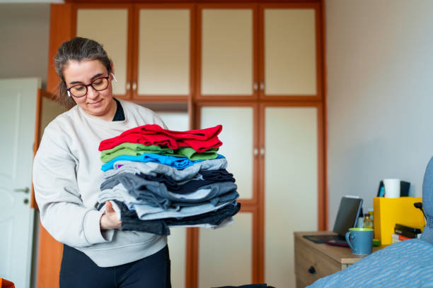istock Woman folding clothes on bed. 1458583404