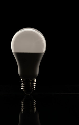 White LED lamp on a black background. The concept of saving electricity