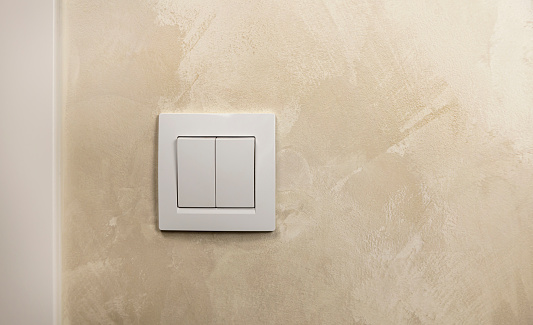 Turn the light on or off. A white light switch on the wall