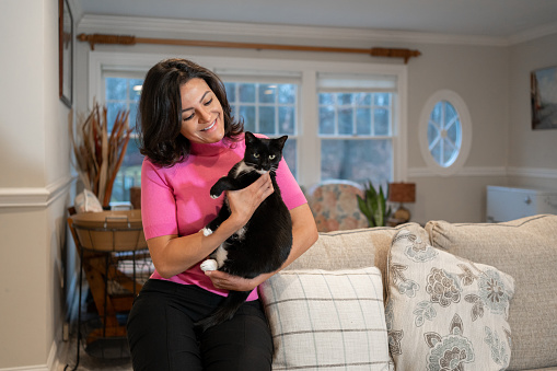 Latin woman with her adopted cat at home