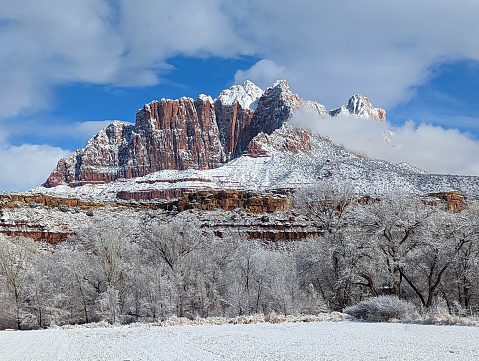 Mt Kinesava in Zion National Park and snow-covered pasture as clouds clear