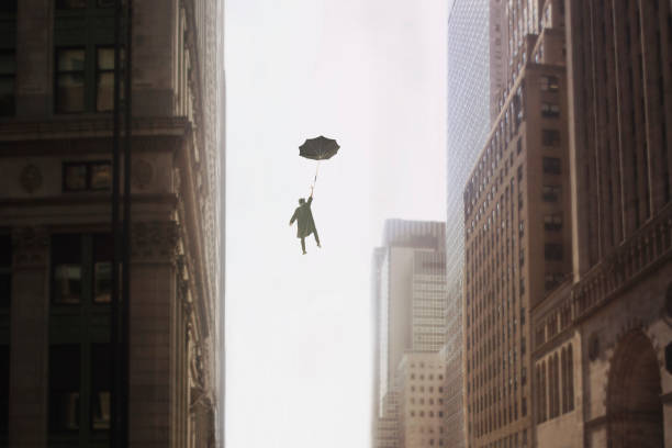 uomo surreale con l'ombrello vola nel cielo tra gli edifici di una metropoli - storm sea business uncertainty foto e immagini stock