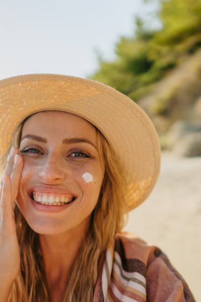 istock Young woman applying sunscreen at the beach 1458599566