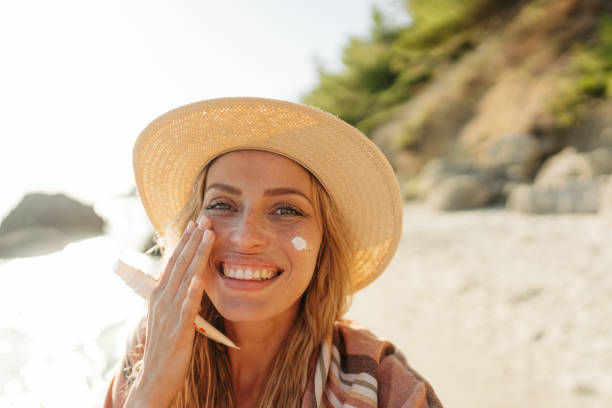 istock Young woman applying sunscreen at the beach 1458599570