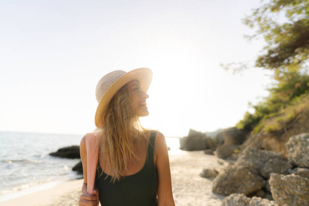 istock Smiling young woman at the beach 1458599613