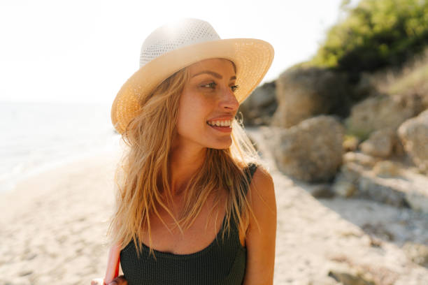 istock Smiling young woman at the beach 1458599624