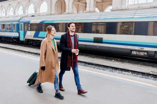 istock Couple walking along railroad station platform 1458601477