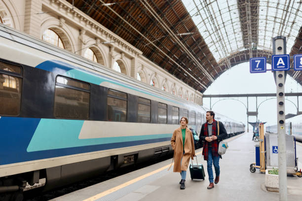 istock Couple walking along railroad station platform 1458602517
