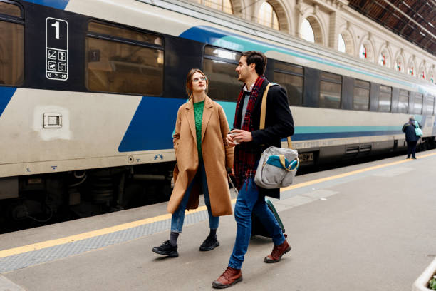 istock Couple walking along railroad station platform 1458602546