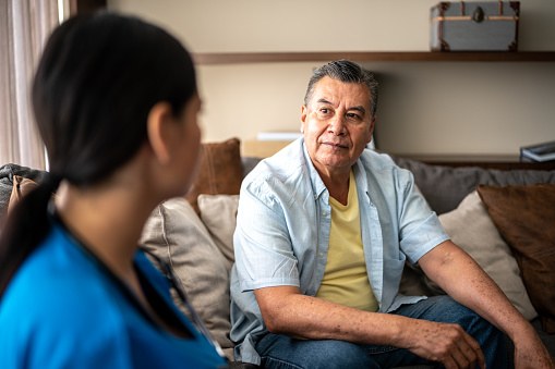 Mature man talking with his nurse during consultation at nursing home