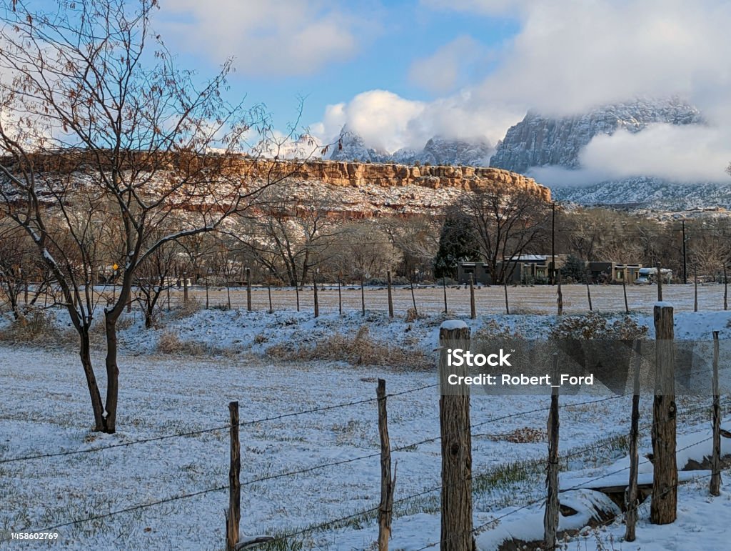 View of the snow-capped mountains in Zion National Park in winter as seen over ranch pastures along the Virgin River in Rockville Utah Agricultural Field Stock Photo