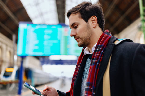 istock Young businessman using his phone at a railroad station 1458602963