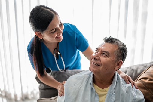 Mature man talking with his nurse during consultation at nursing home